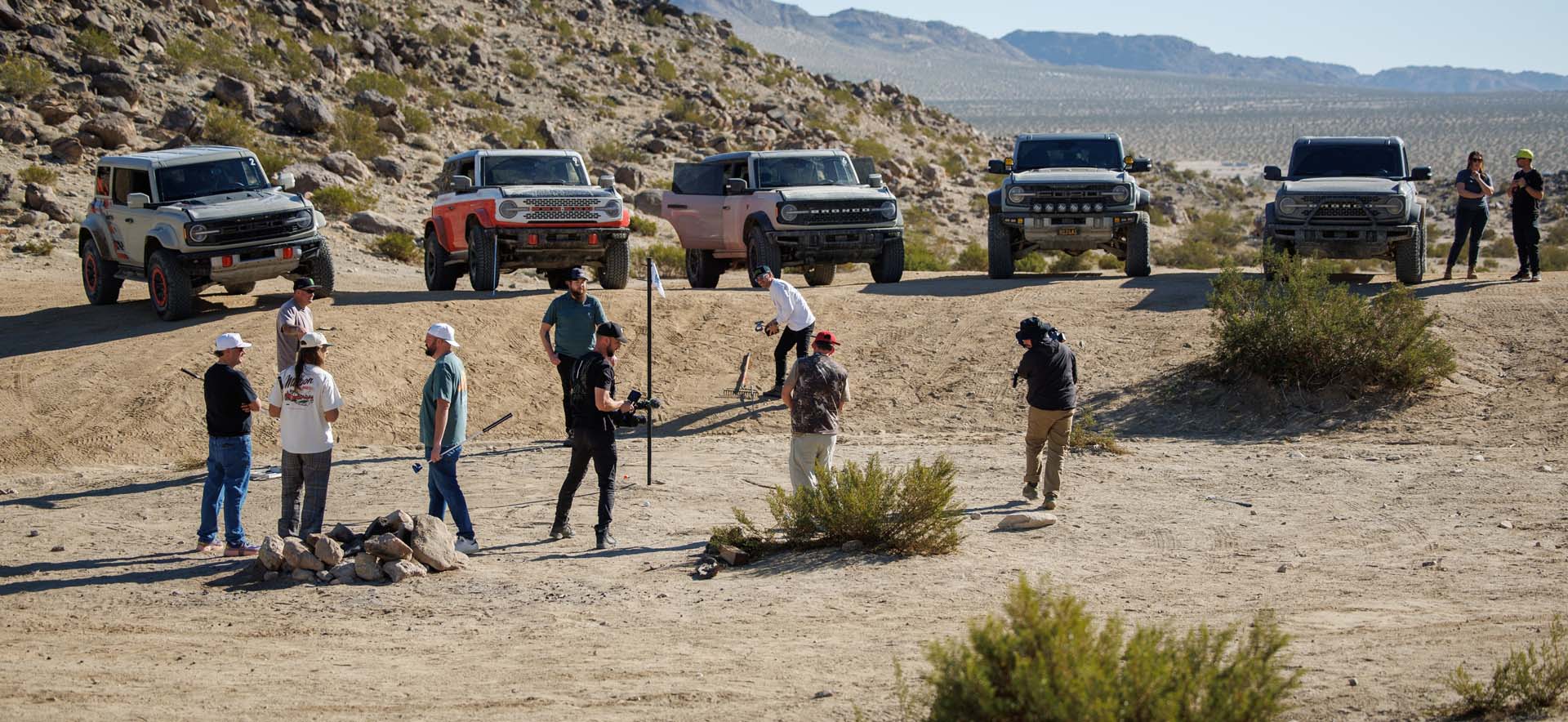 Broncos in desert with people golfing
