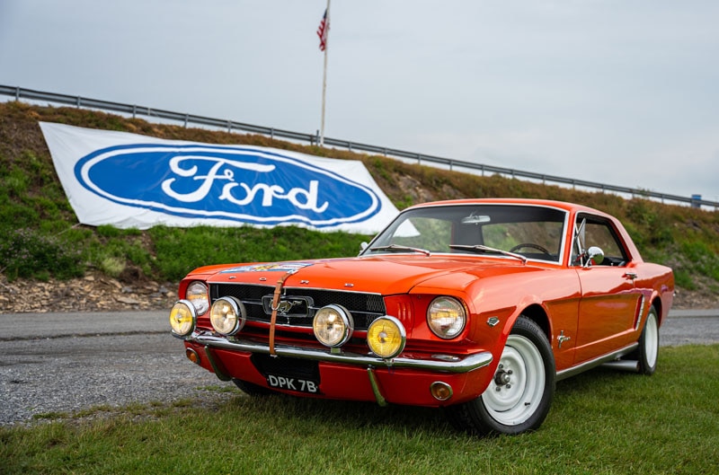 Ford Mustang in front of Ford logo on grass