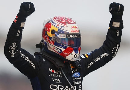 Max on podium with hands up