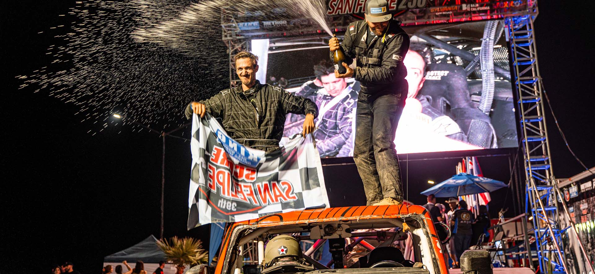 Drivers on car on podium 