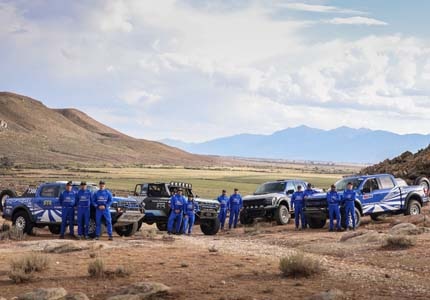 Team photo with vehicles
