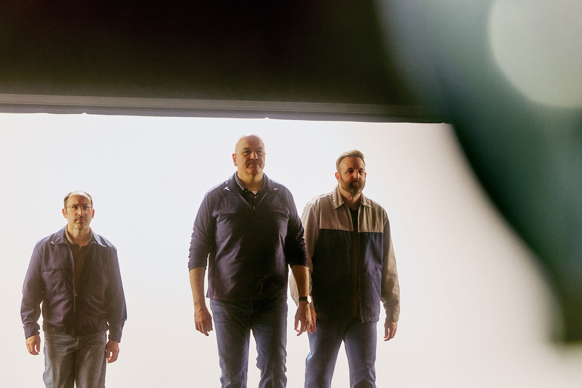 Ford engineers walking into a garage backlit by daylight