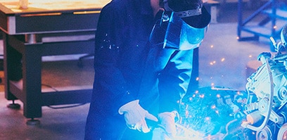 An engineer welding in a garage