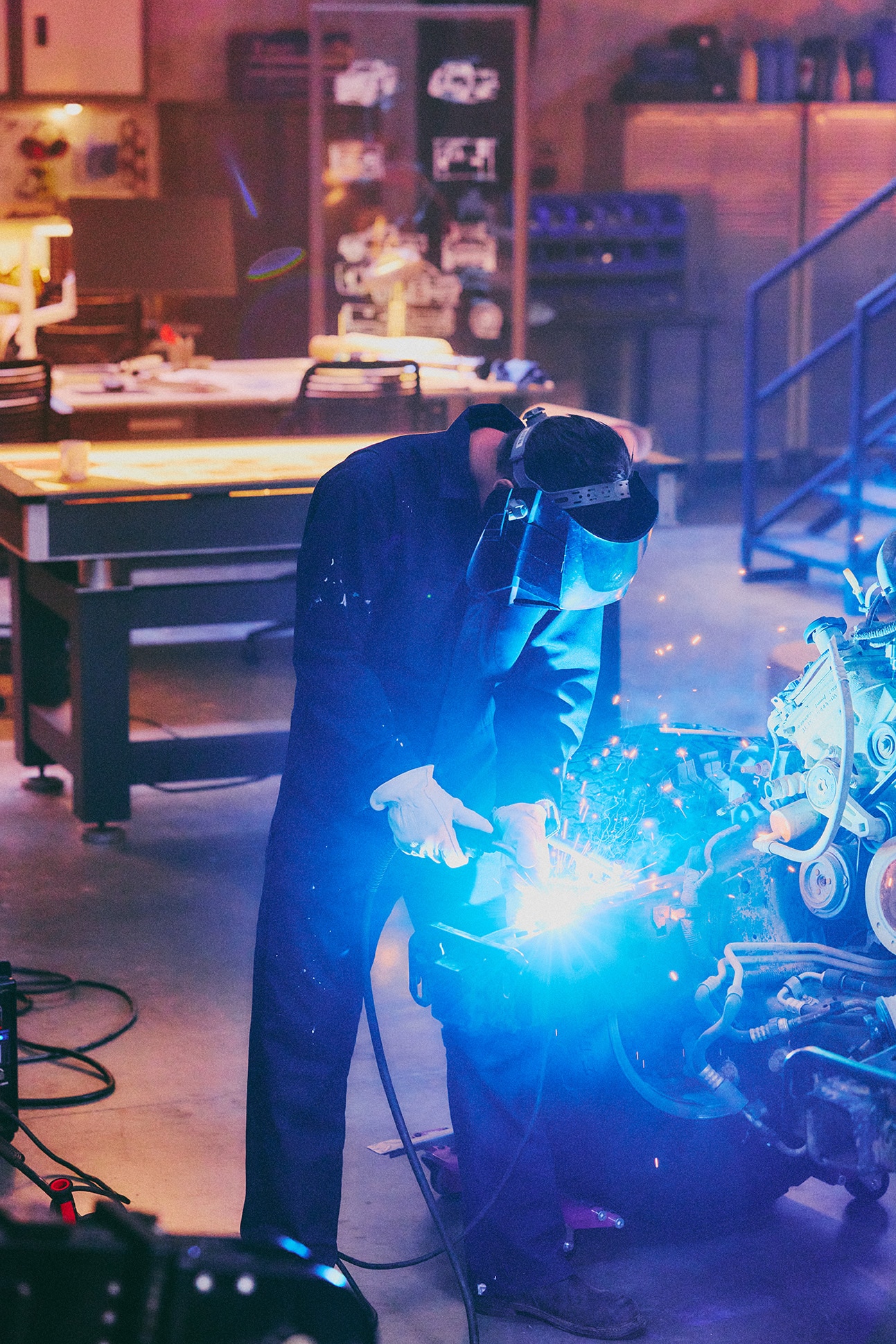 An engineer welding in a garage