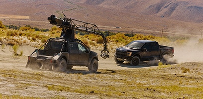 Truck mounted camera filming a Ford Raptor from the front