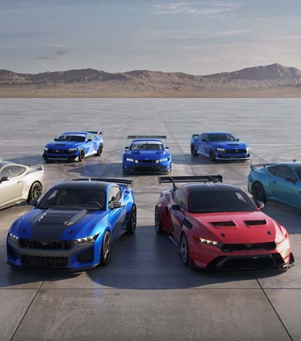 Blue and silver Ford vehicles on pavement, including GT3, GT4 and Ford Mustang race cars
