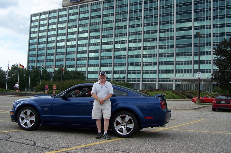 Tom Welsh with Ford Mustang and Ford World Headquaters in the background