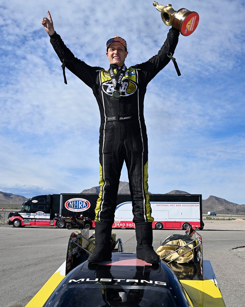 Tasca standing on Mustang with trophy