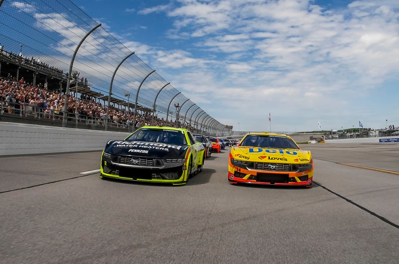 Two Ford Mustang Dark Horses side by side on track