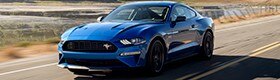 Blue Mustang driving down a highway